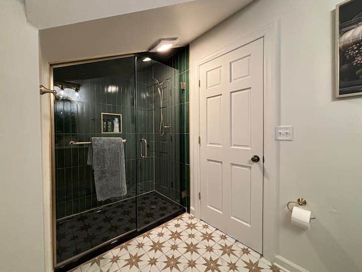 Modern bathroom with a sleek glass walk-in shower, rich tile accents, and stylish finishes
