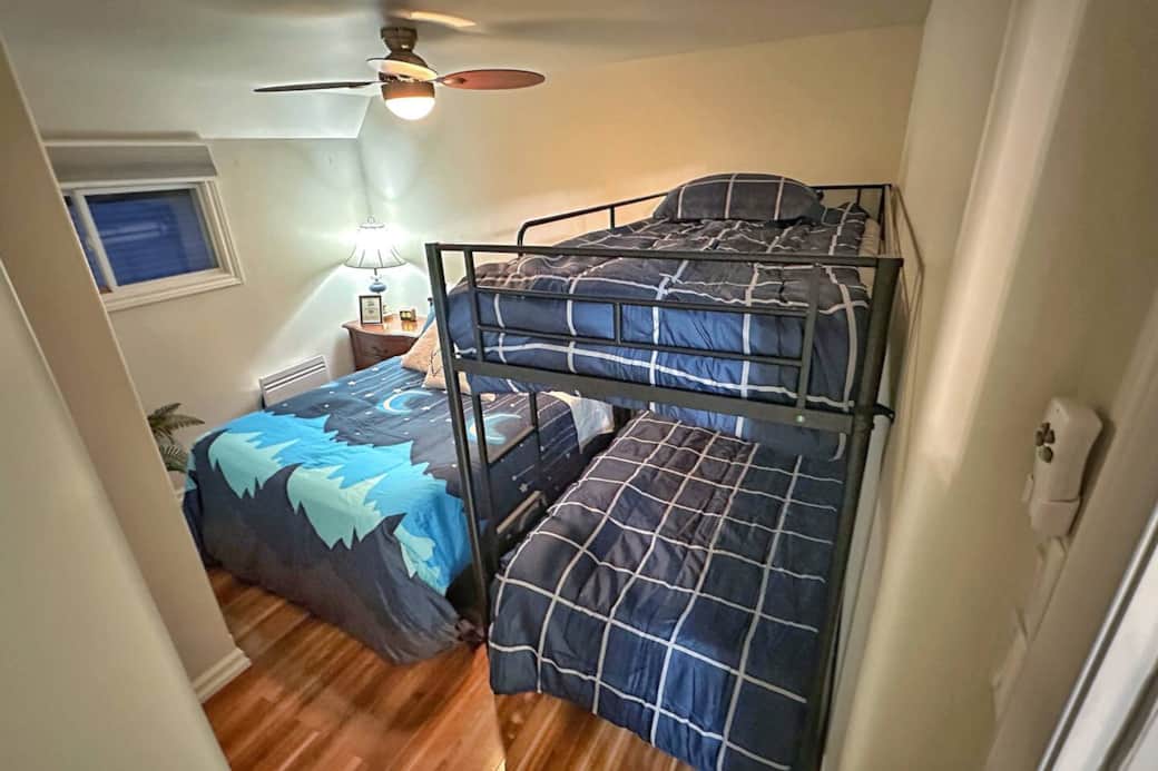 Cozy second bedroom offering plenty of sleeping space with a full bed and bunk setup.
