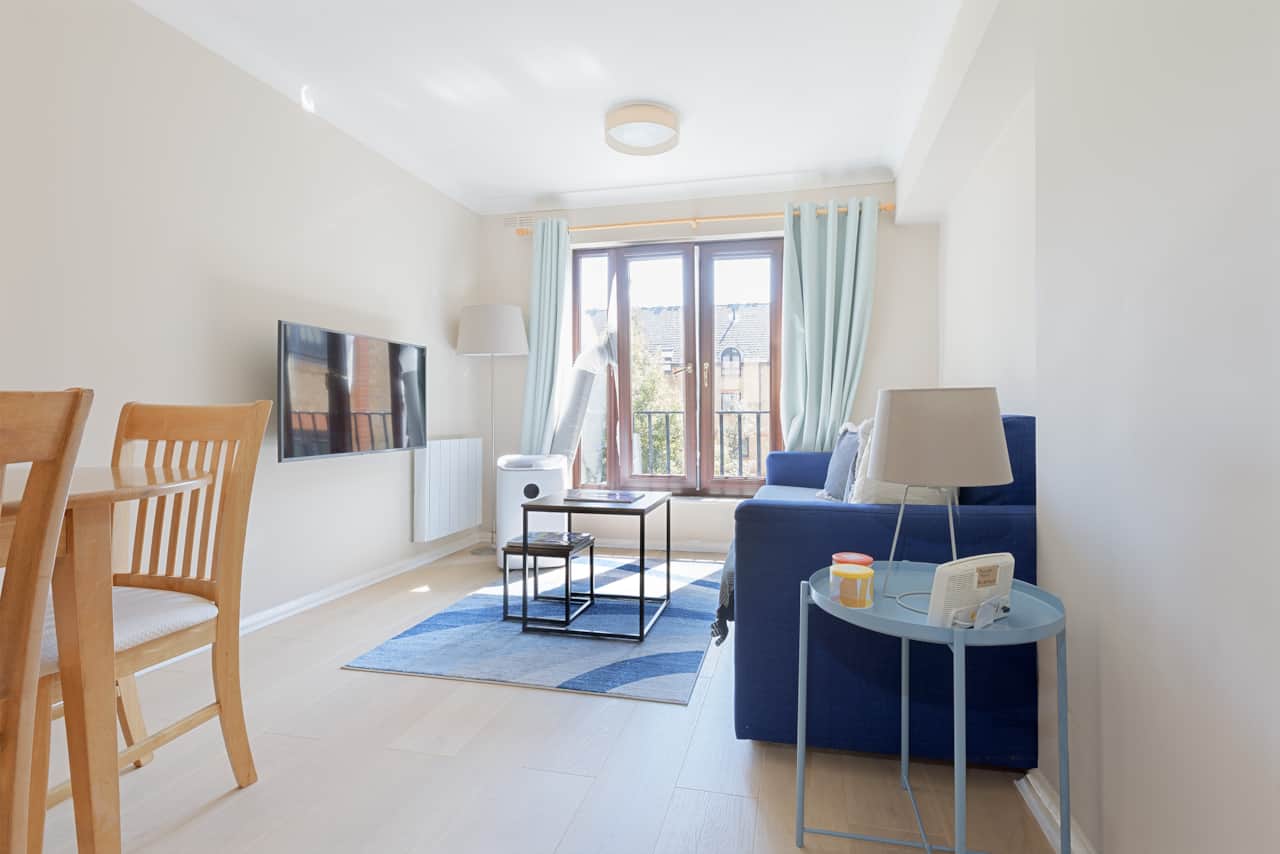 Bright open plan living room with balcony and blue accent sofa