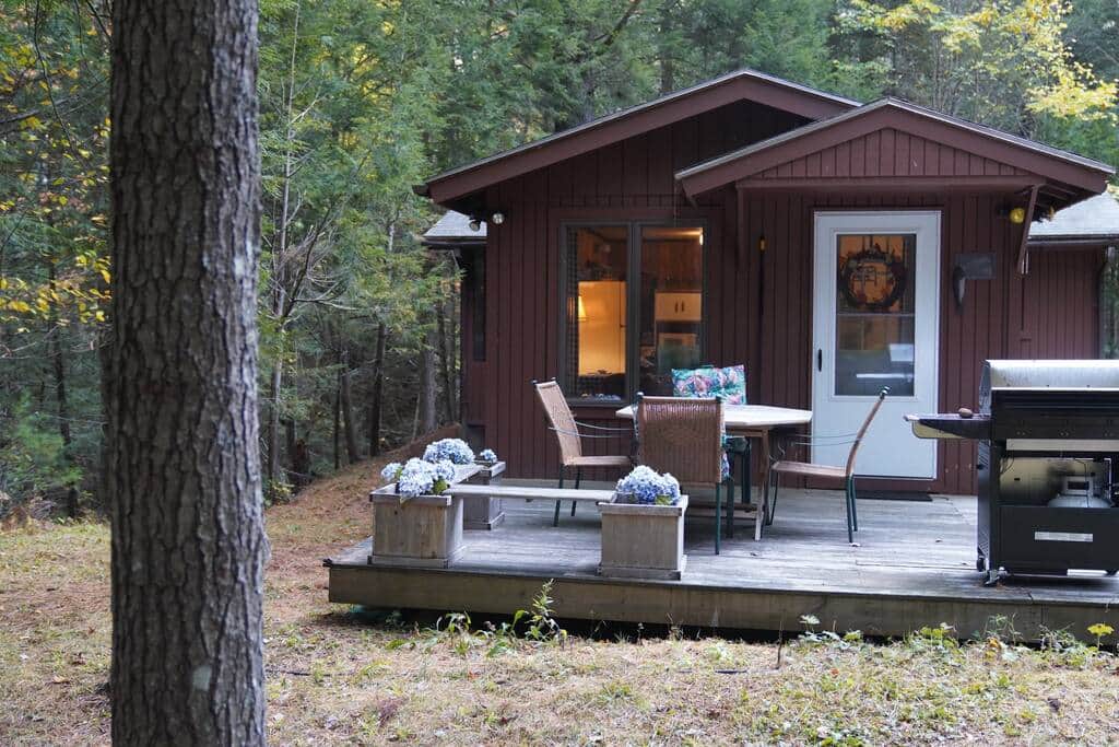 Cabin entrance with table and BBQ.