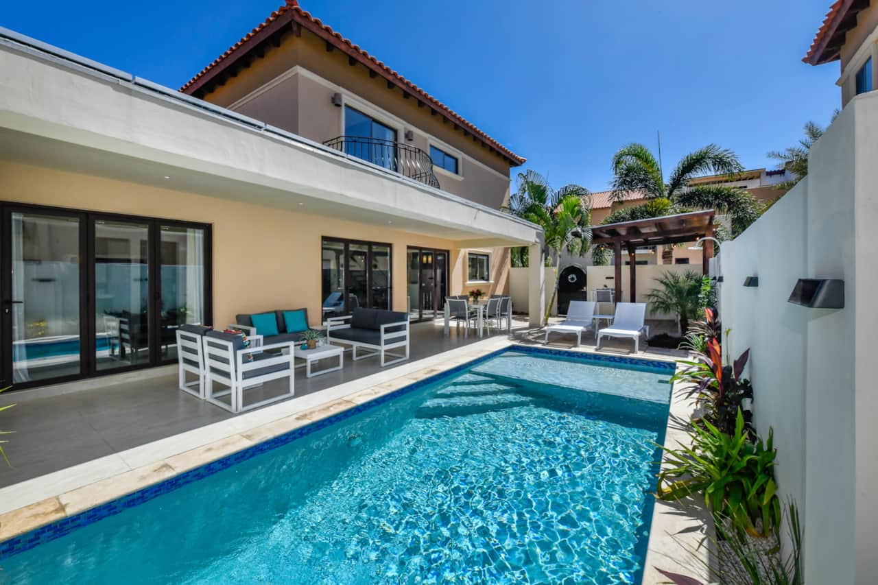 Backyard with pool, dining table, BBQ, conversation set, bar table seating, and sun loungers
