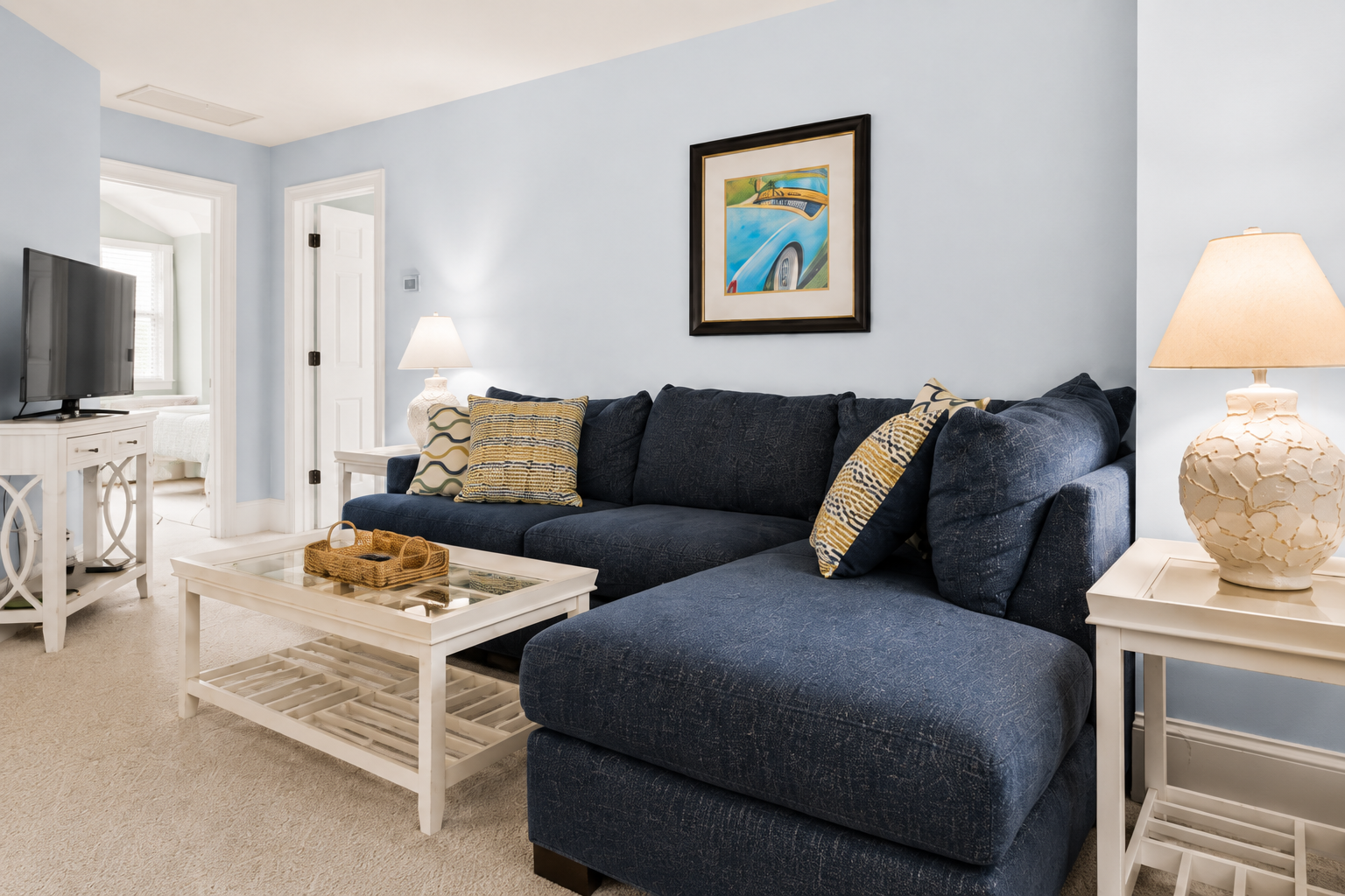 Claim a corner of the navy sofa and flip on the TV across the room.