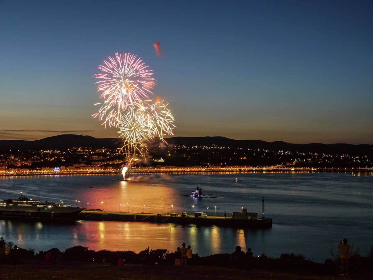 Fireworks over Douglas Bay with the promenade lights along the shore