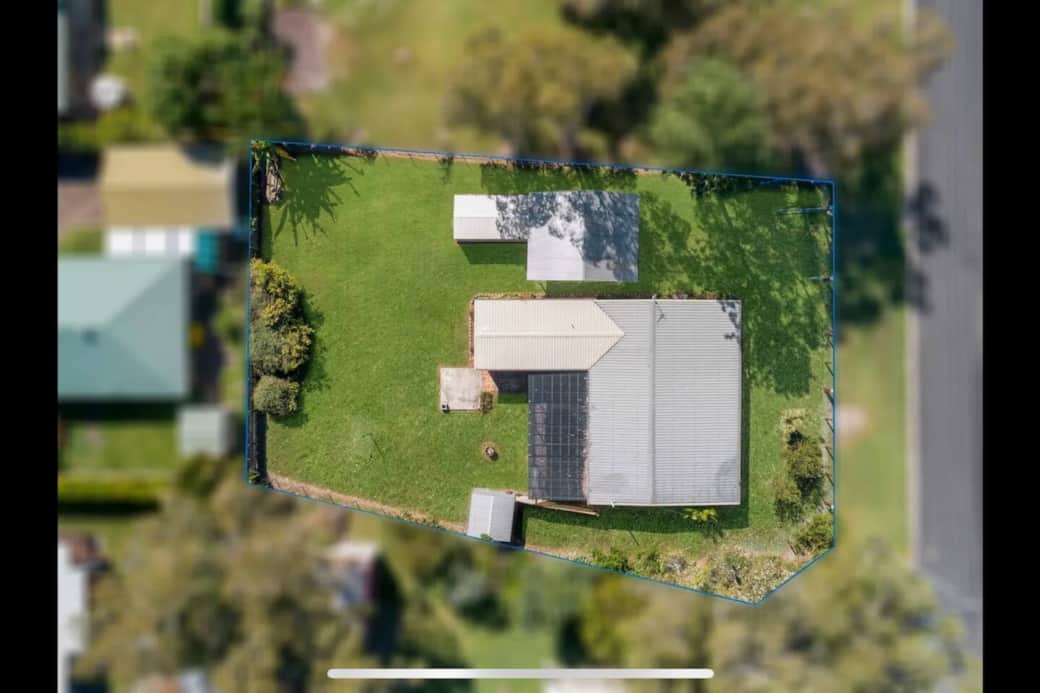 Aerial view of the property showcasing the expansive, fully fenced yard—plenty of room for pets and kids to run wild or kick a footy, all while you unwind in the covered outdoor entertaining area.
