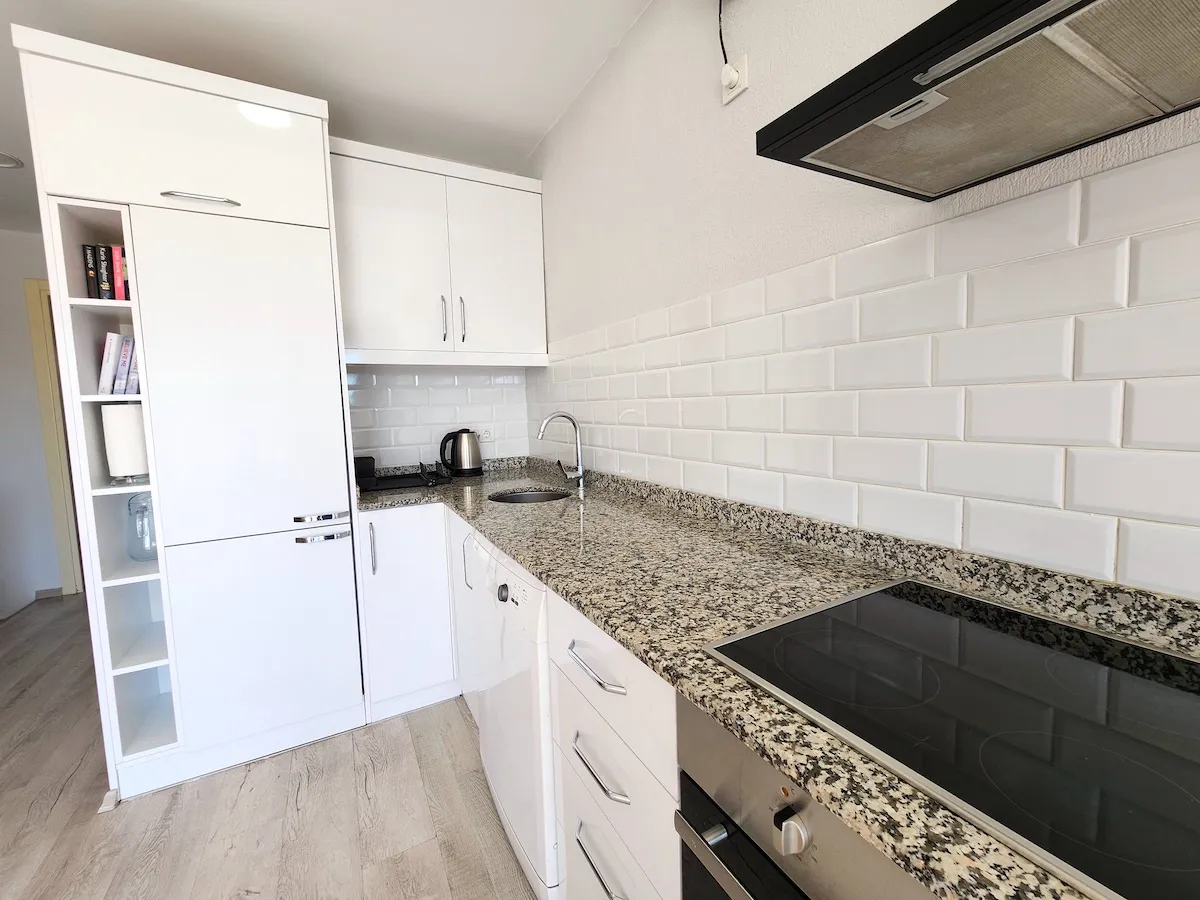 Modern kitchen with white cabinets, granite countertops, and appliances in Apart Guney 4, Göcek.