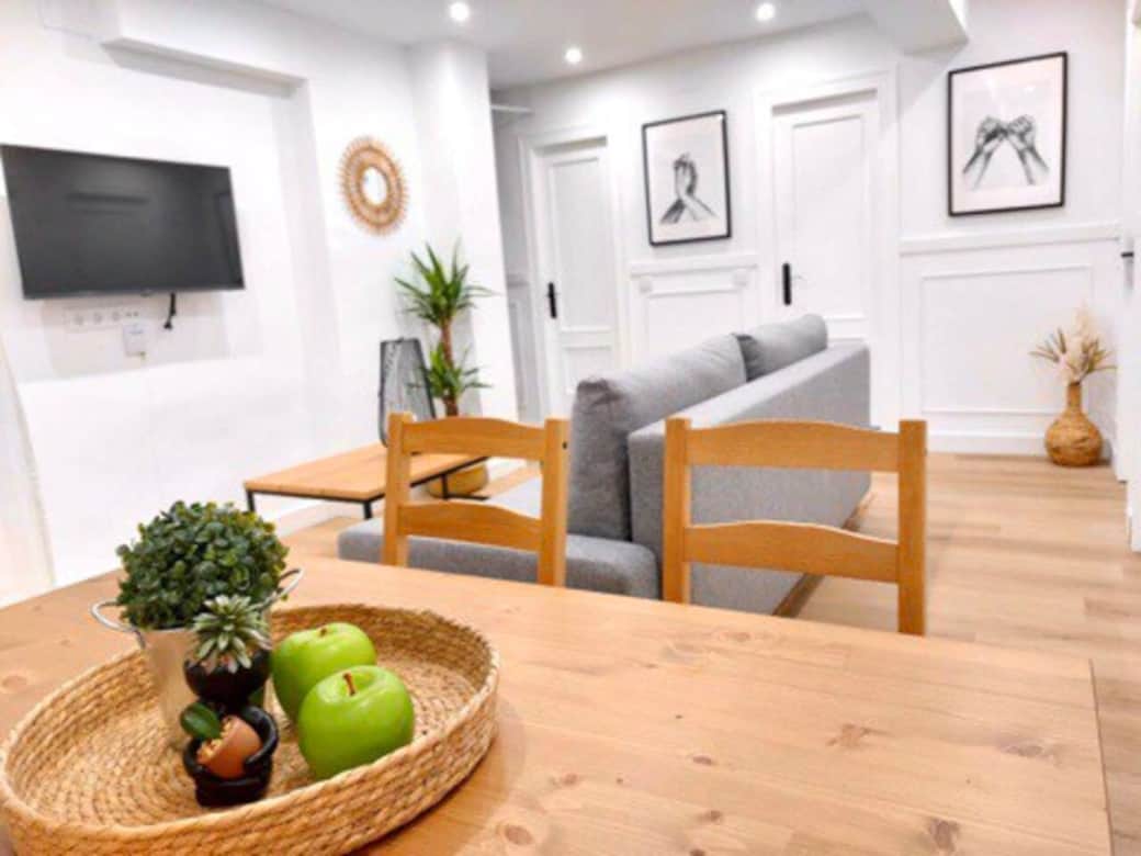 Salón comedor con sofá grande, tv y mesa para hasta seis comensales.
