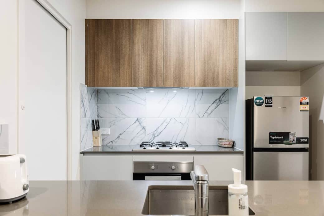 Welcome to the modern kitchen designed for both functionality and style. With high-end stainless steel appliances and a gas stove, cooking here is a breeze. The marble backsplash adds a touch of luxury, making every meal a delightful experience.