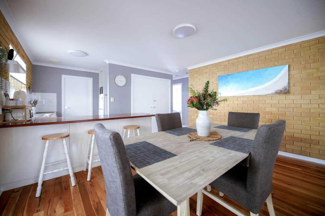 Dining table seats four, with three stools at the kitchen bench. High chair is stored in the wardrobe of Bedroom One (Queen Room).