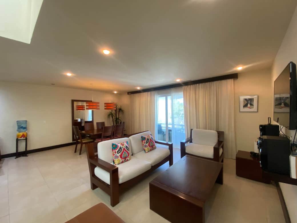 Living room. Dining room in background. Windows lead to balcony with beach view. Living room. Dining room in background. Windows lead to balcony with beach view.