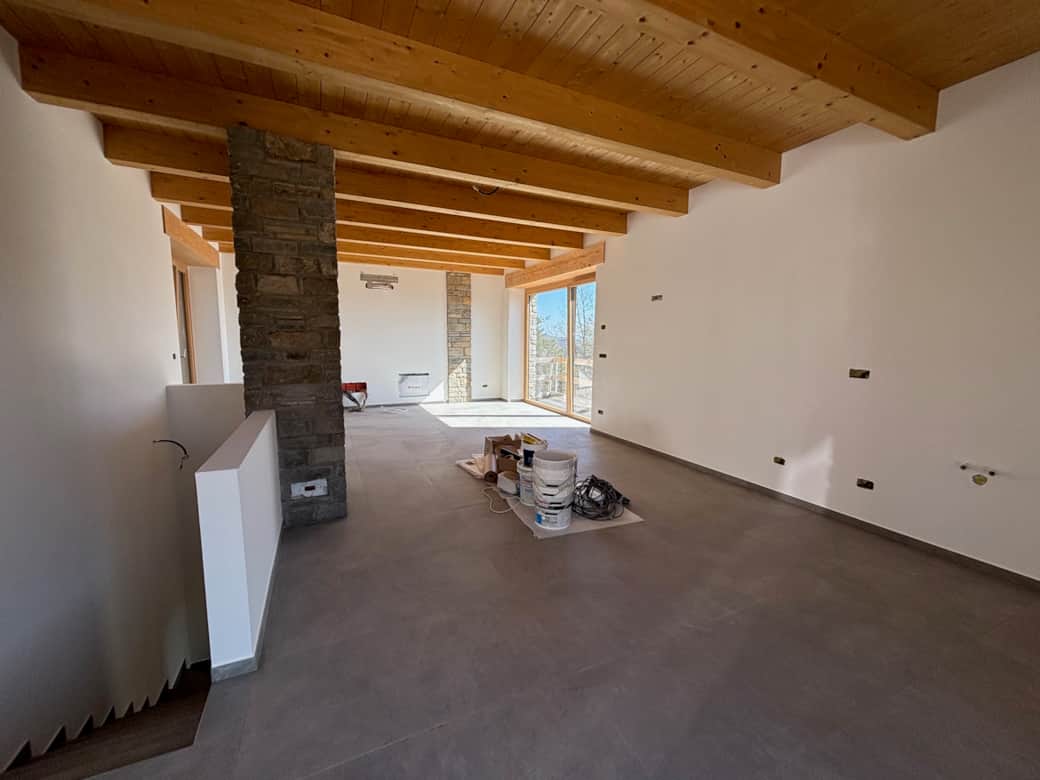 PINI - Bau Living/Küche mit hellen Fenstertueren und warmer Holzdecke Treppe zu den Schlafzimmern