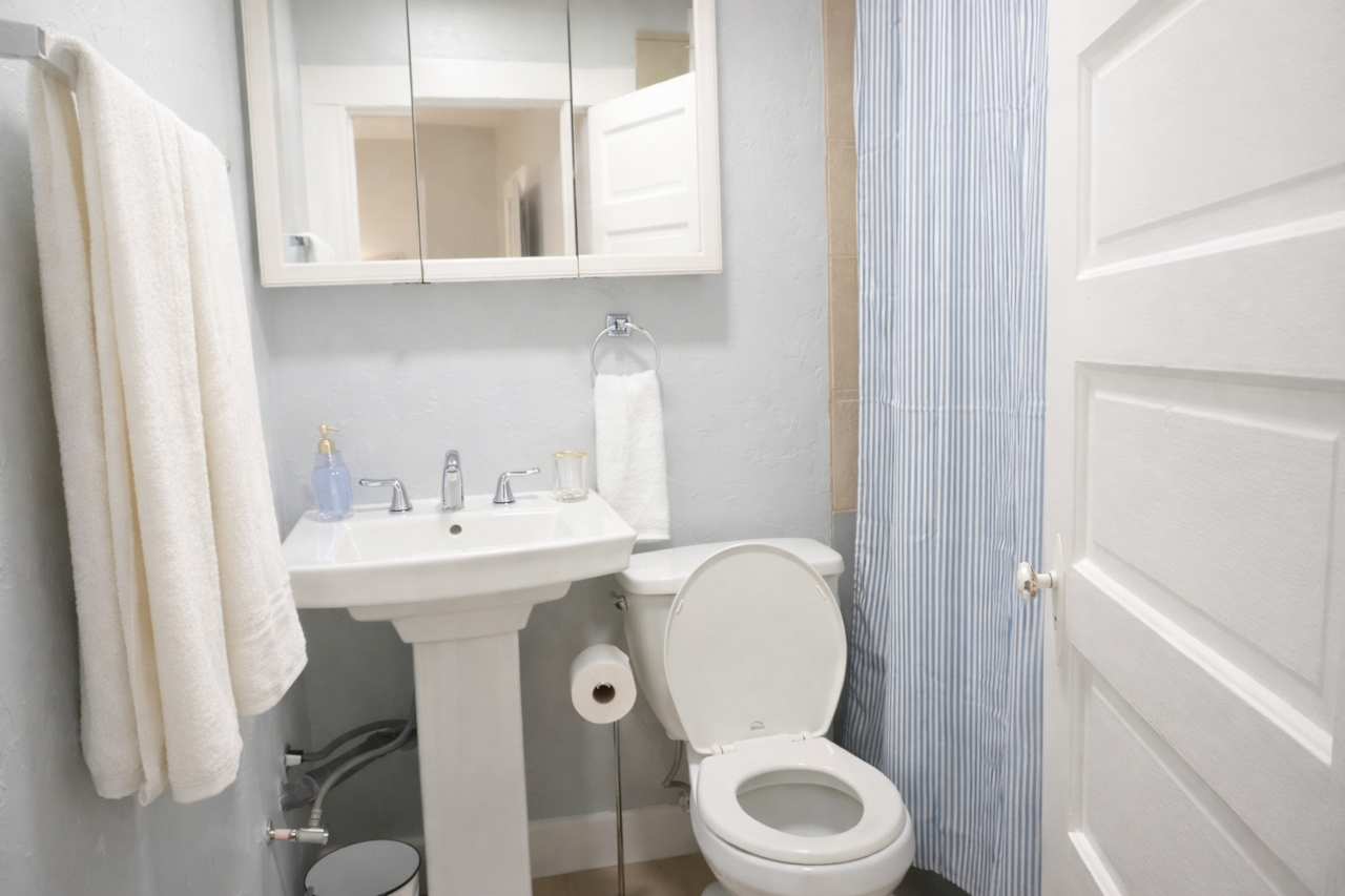 Bright, clean bathroom and shower tub with fresh towels and essentials provided