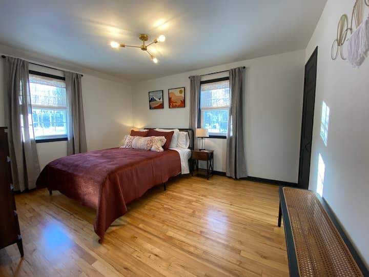 Comfortable bedroom with a plush bed, warm tones, and soft lighting.