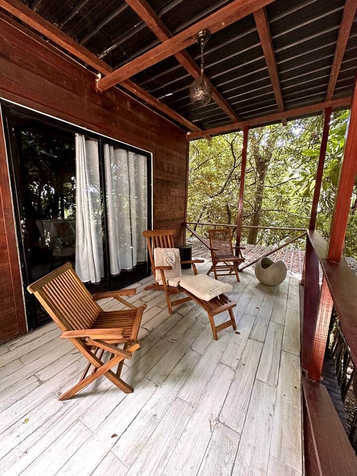 Teak chairs on the Deluxe Cabin deck among the trees, Saboga Lodge, Saboga Island, Panama