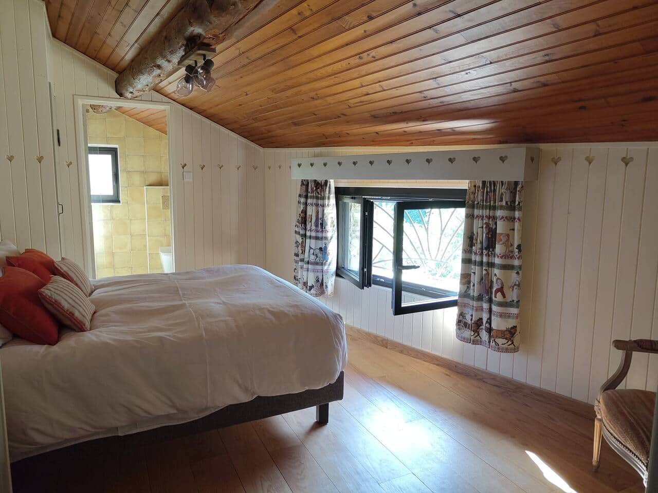 Chambre lambrissée, avec vue sur le village.