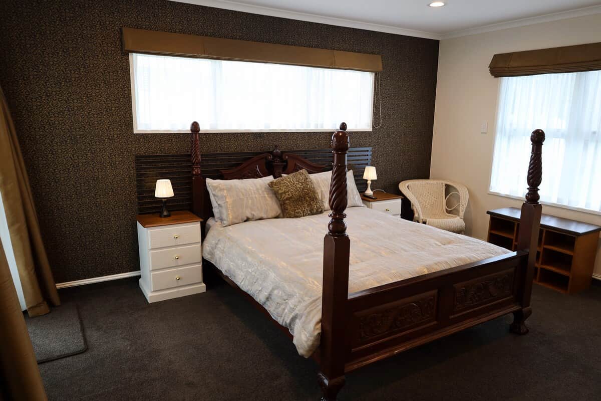 Master Bedroom with four-poster Queen bed, walk-in wardrobe, and patio access—sleeps 2 guests.