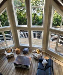 Looking down from the loft at the living room, overlooking the deck and the lake