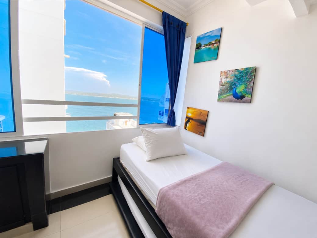 Cama y ventana con vista al Mar Caribe