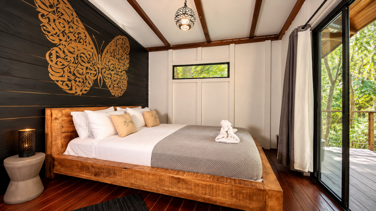 Wood platform bed and butterfly mural in the Deluxe Cabin, Saboga Lodge, Pearl Islands, Panama