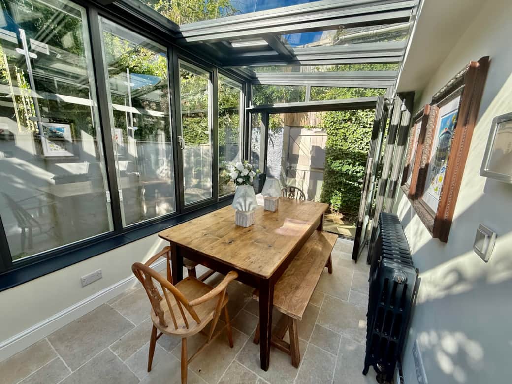 Spacious dining area with large rustic wooden table and vintage bifold doors