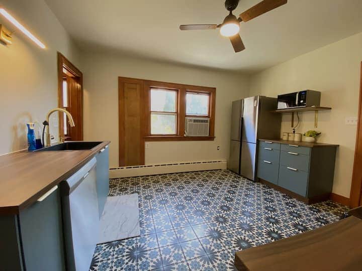 Spacious eat-in kitchen with stylish patterned tile floors, modern appliances.