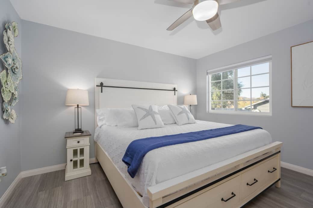 Relax in comfort and style in the master bedroom featuring a plush king bed, soft coastal décor, and plenty of natural light — your peaceful retreat at The Birdhouse SD. Relax in comfort and style in the master bedroom featuring a plush king bed, soft coastal décor, and plenty of natural light — your peaceful retreat at The Birdhouse SD.