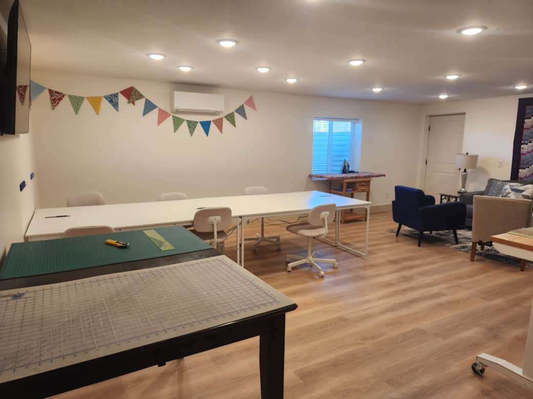 Sewing studio for six has two cutting tables, two ironing stations, and comfortable sewing chairs.