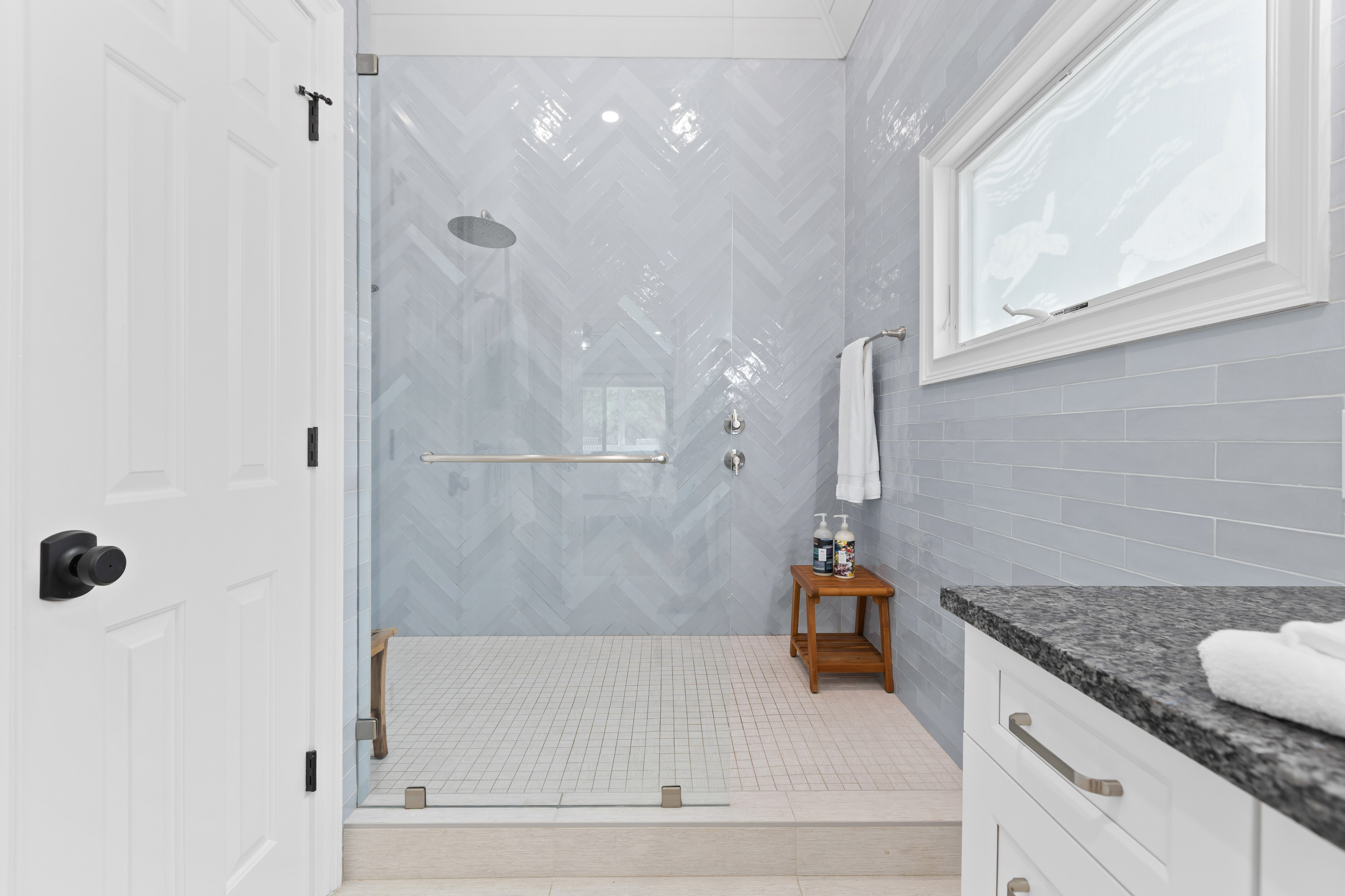 Step into the spacious glass shower, with fresh towels and bath essentials kept close at hand.
