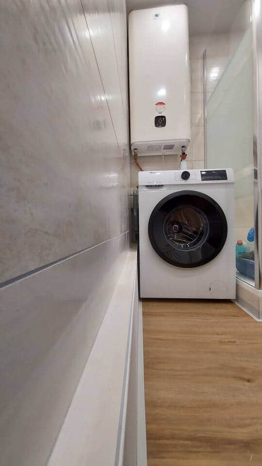 Le lave linge 8kg, dans la salle d'eau.