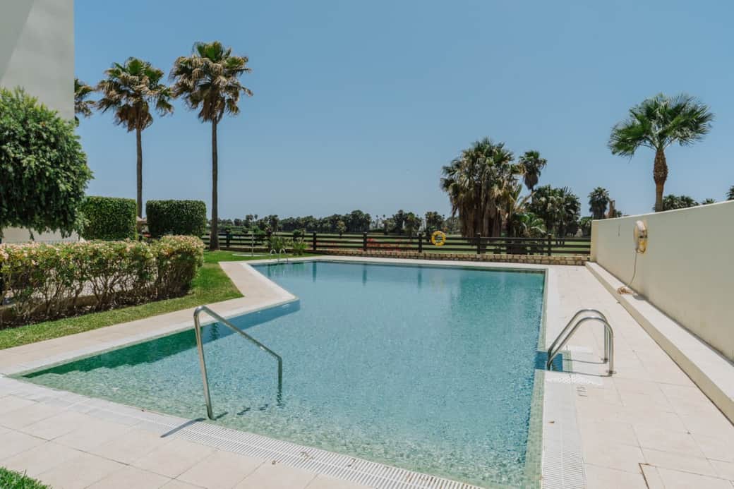 Sumérgete en esta piscina rodeada de palmeras, donde el sonido del agua y la brisa crean una atmósfera de descanso total.