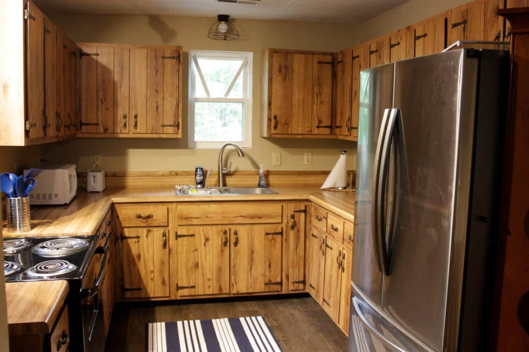 Rustic kichen with full size refrigerator stocked with water and has an automatic ice maker
