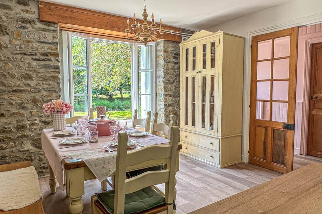 Dining area with river view, open-plan kitchen, vintage table and curated tableware