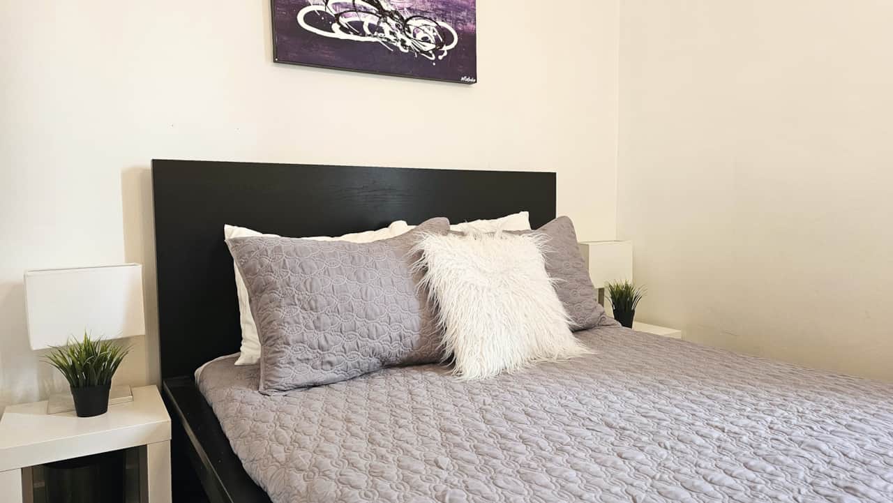 Second bedroom with double bed, neutral tones, and comfortable linens in a quiet main-floor Moncton 