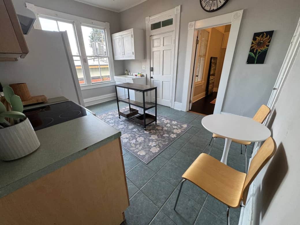 The kitchen is fully stocked with dishes, glassware, and appliances, providing everything you need to cook and enjoy meals. A small café table for two offers a cozy dining spot.