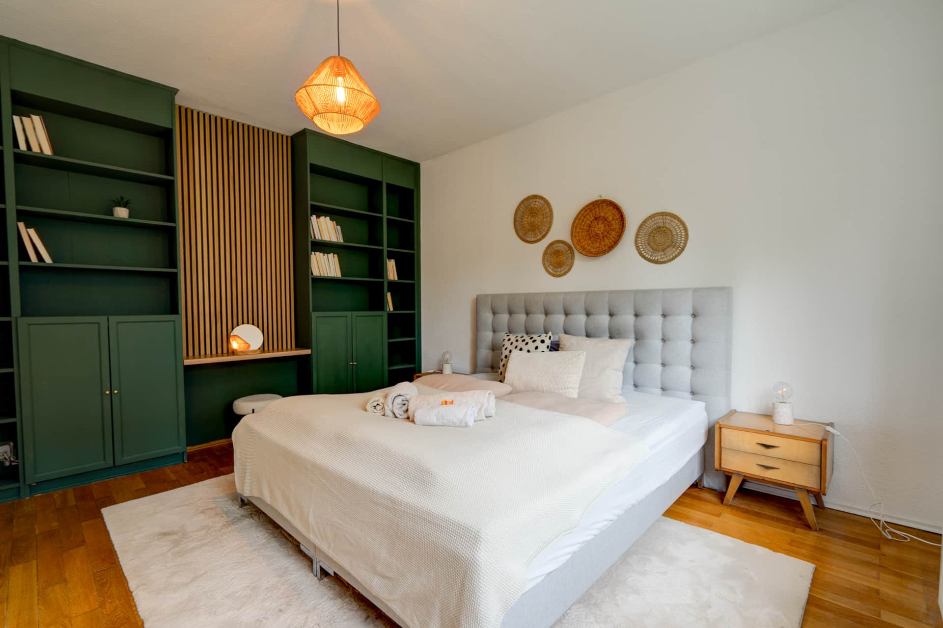 Bedroom of the Herkules apartment with green shelves and a double bed