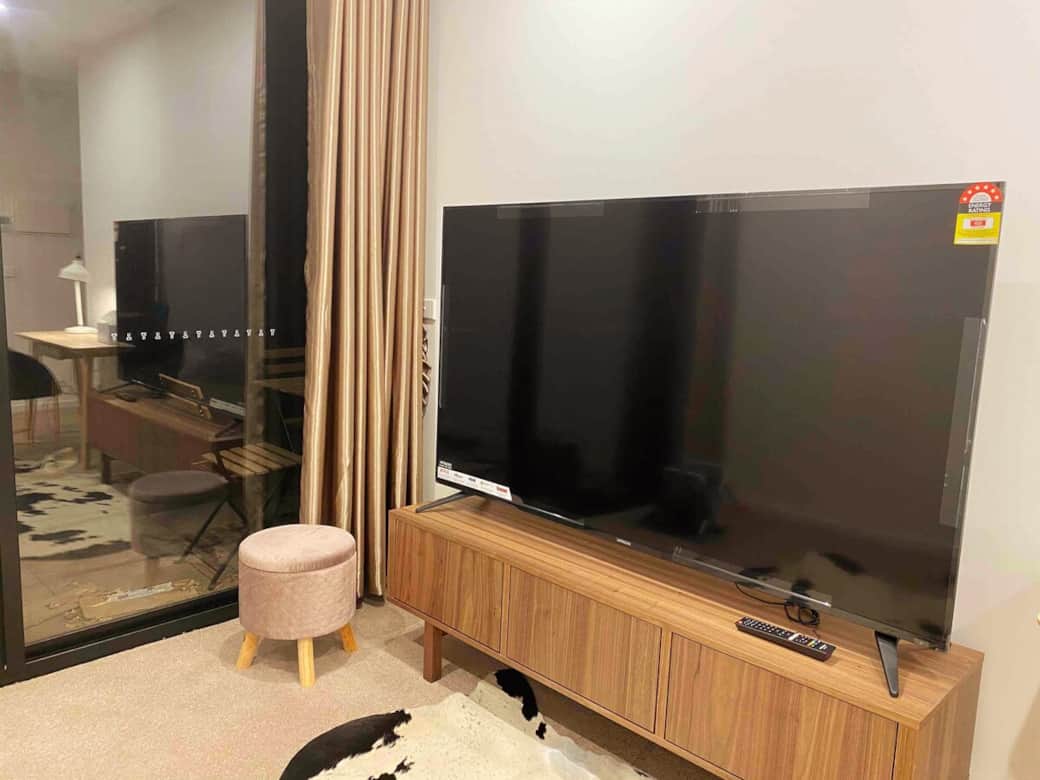 Relax in style with our spacious living area featuring a large flat-screen TV and a cozy sofa. The modern design and warm lighting create a welcoming atmosphere for entertainment or simply unwinding after a day out. Enjoy comfort  in the space.
