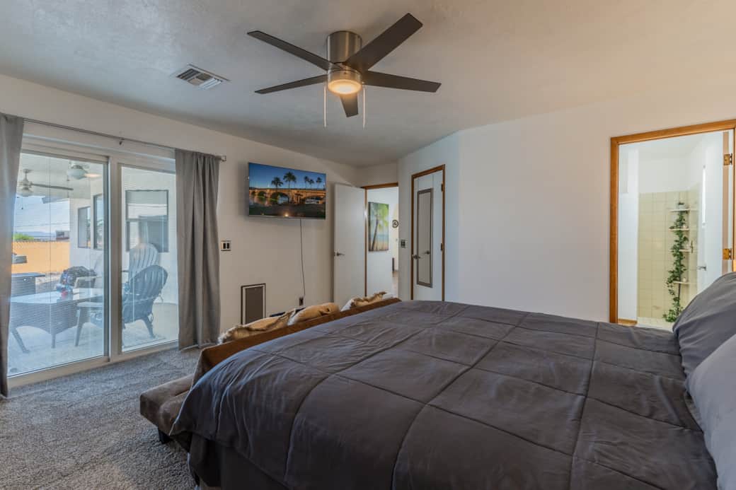 Primary bedroom facing patio with 55 inch smart tv