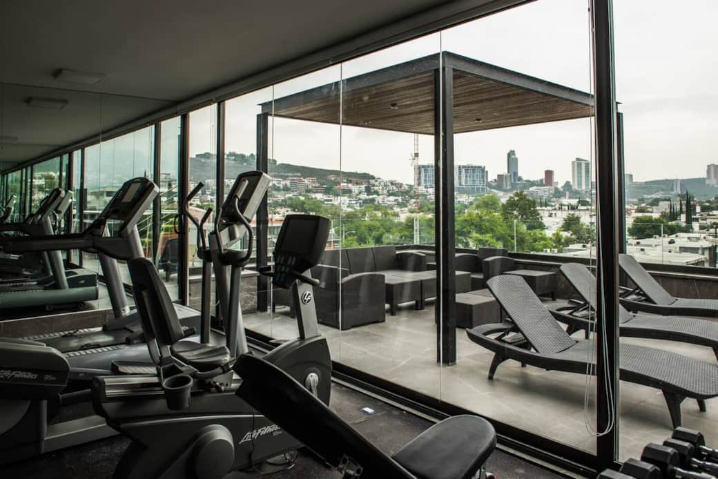 Gimnasio en área de rooftop frente a alberca y asador