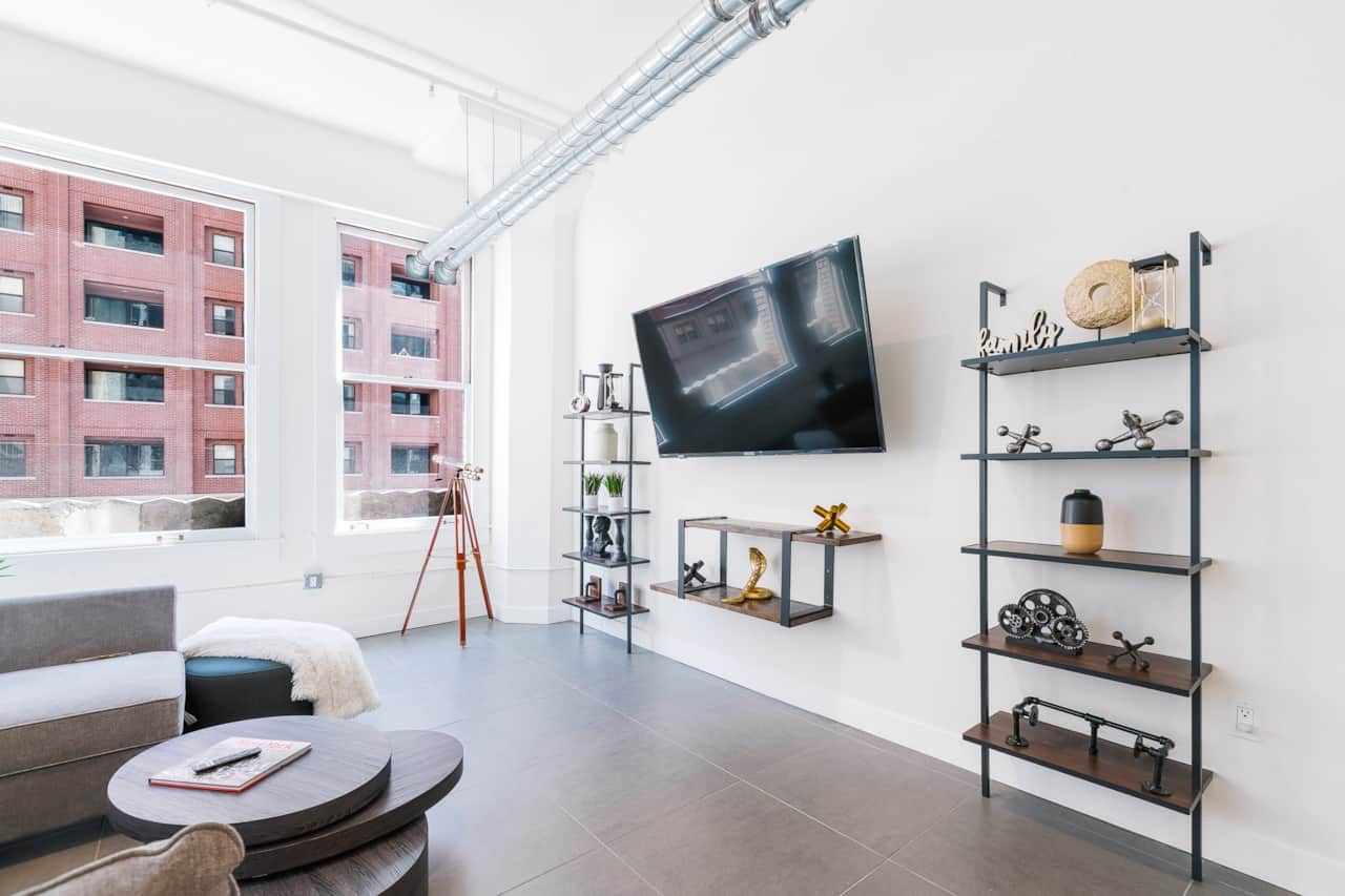 Sunny, spacious living room with cozy seating and a TV, perfect for relaxing.