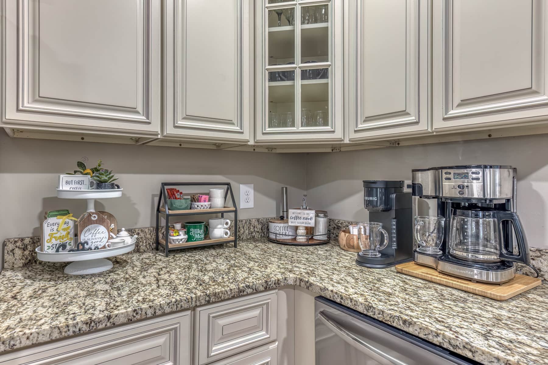 Coffee bar featuring drip coffee maker, Keurig, tea selection, creamers, and sweeteners.