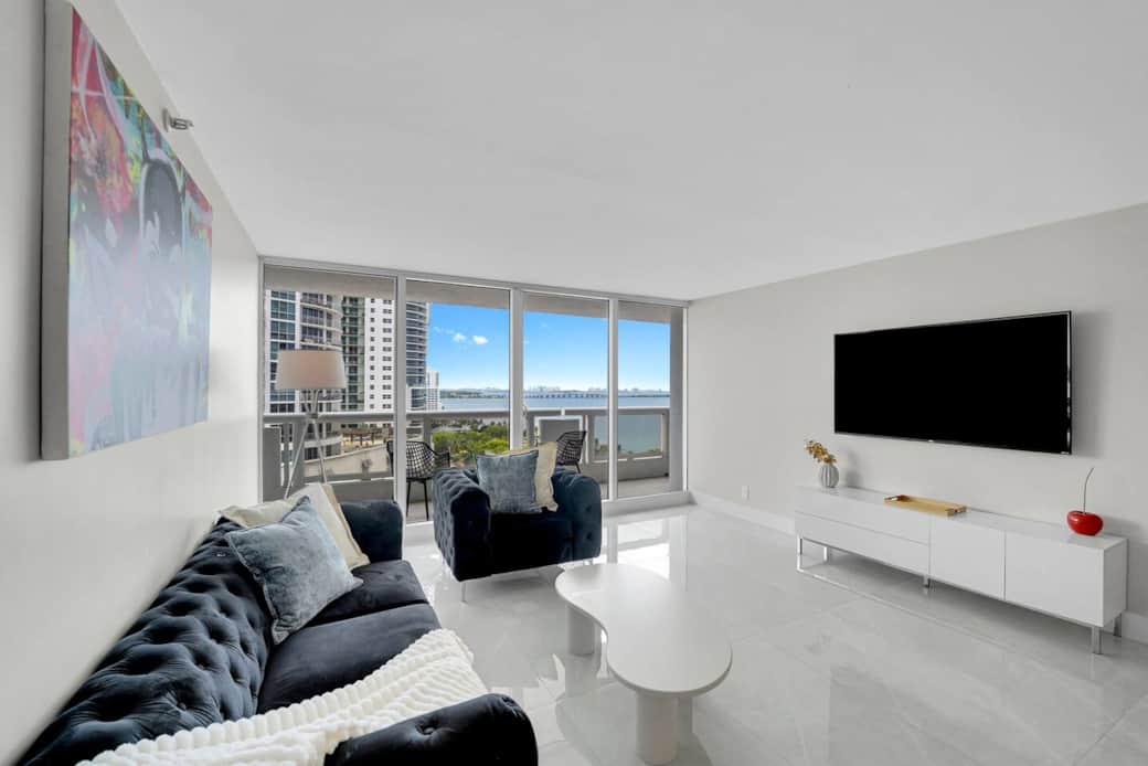 Living room with Roku streaming tv, balcony access with water and park views