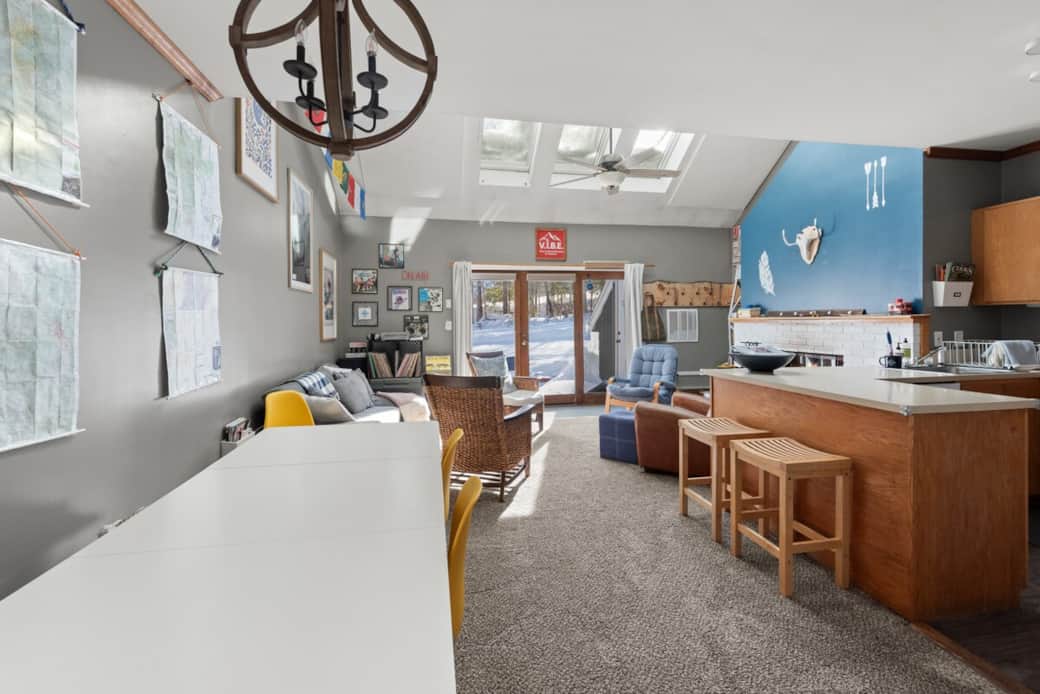 Open concept living room, dining room and kitchen.  Bright and airy space with unique decor, 6 skylights, and doors leading to private back deck and nature, skiing, tubing, disc golf.