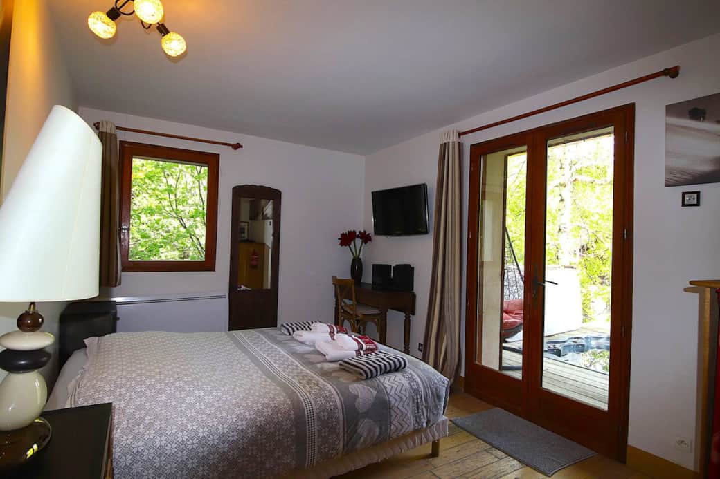 Chambre au R0 composée d'un grand lit double. Elle mène à la terrasse et au jacuzzi.