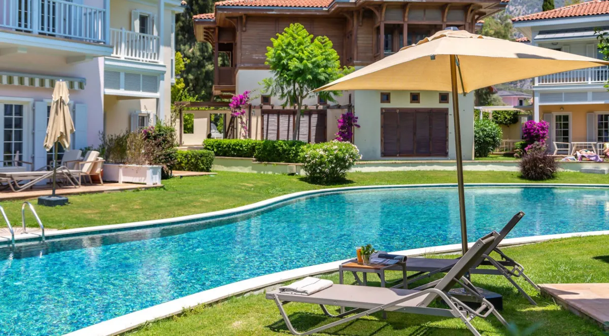 Swimming pool surrounded by green grass and lounge chairs, Portville B2 005, Gocek