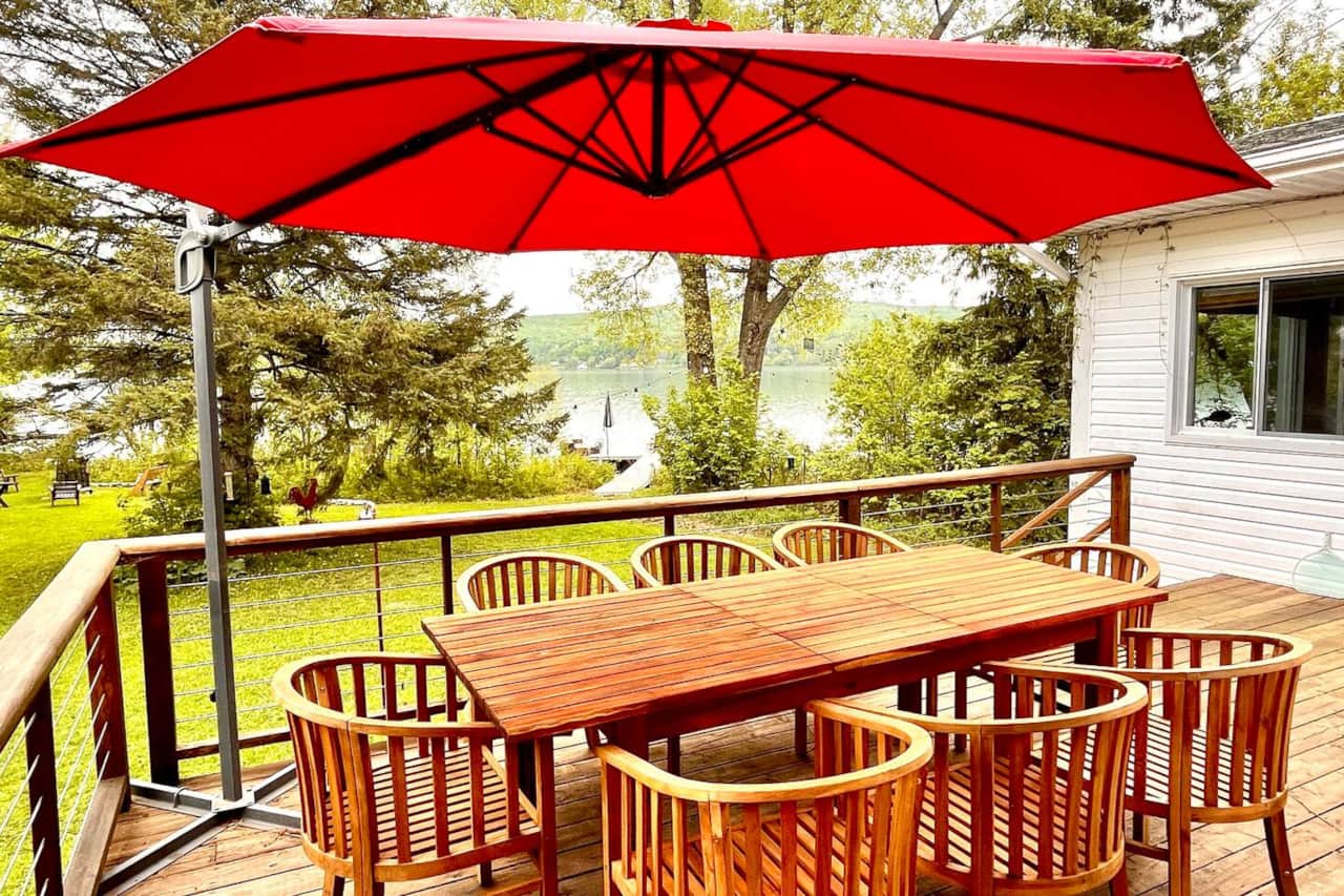 Grande terrasse extérieure avec vue sur le lac; table avec 8 chaises + barbecue + parasol