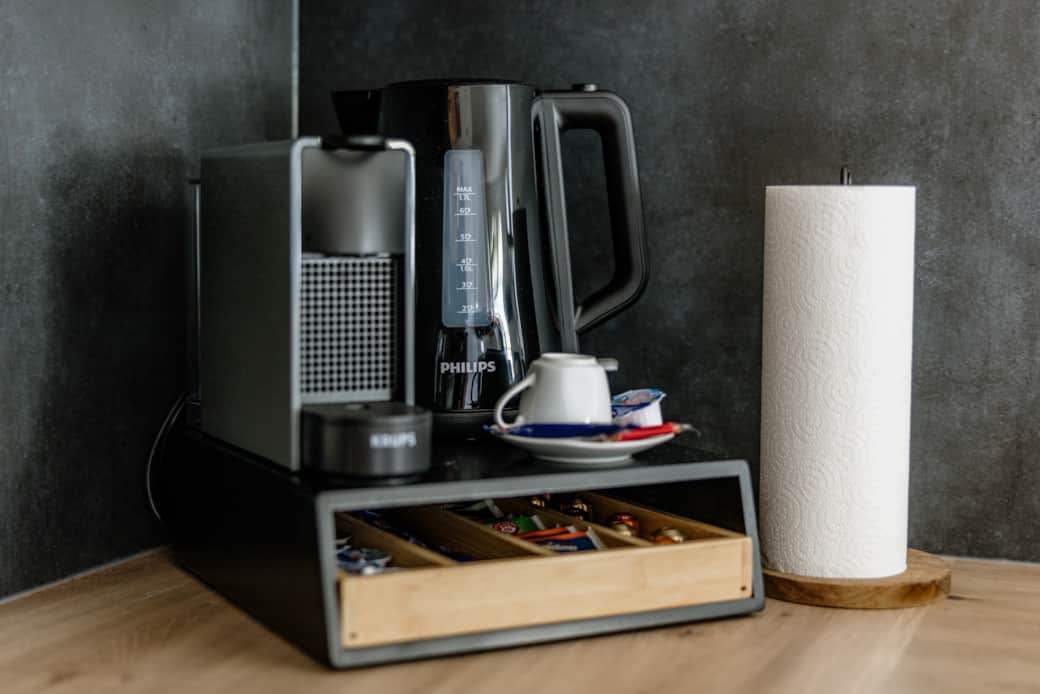 Wasserkocher, Nespresso und in der Schublade Kaffee, Tee, Milch, Sahne und Zucker.