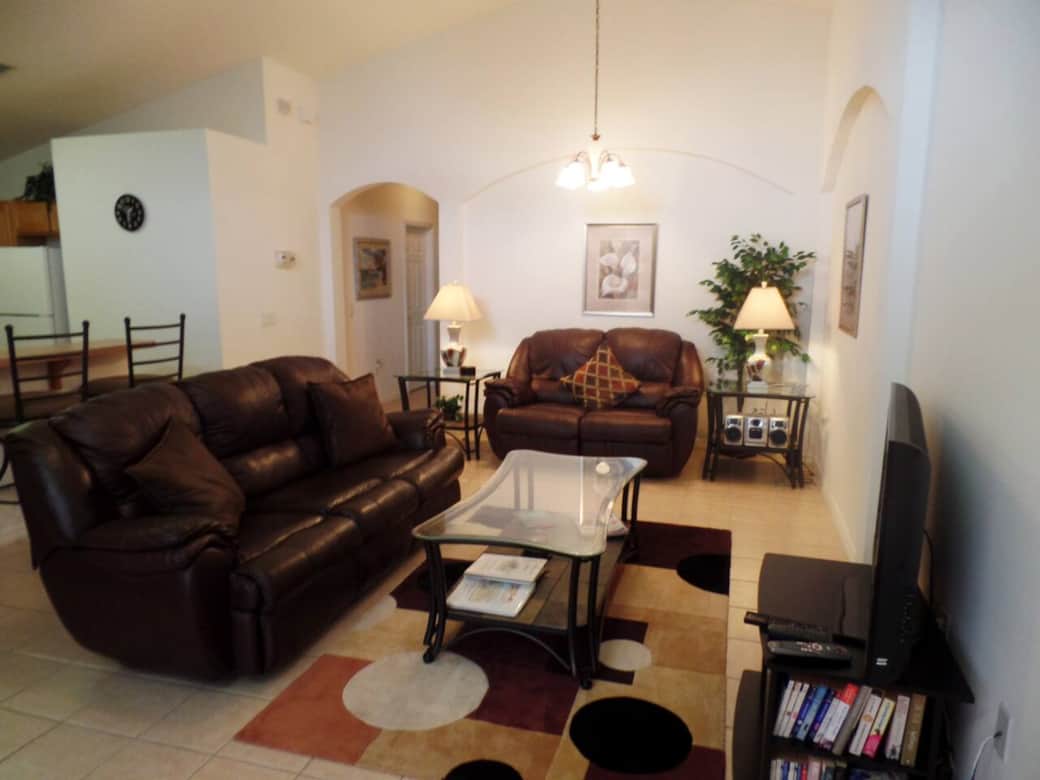 Lounge area with large cable TV, reclining leather sofas and chairs.