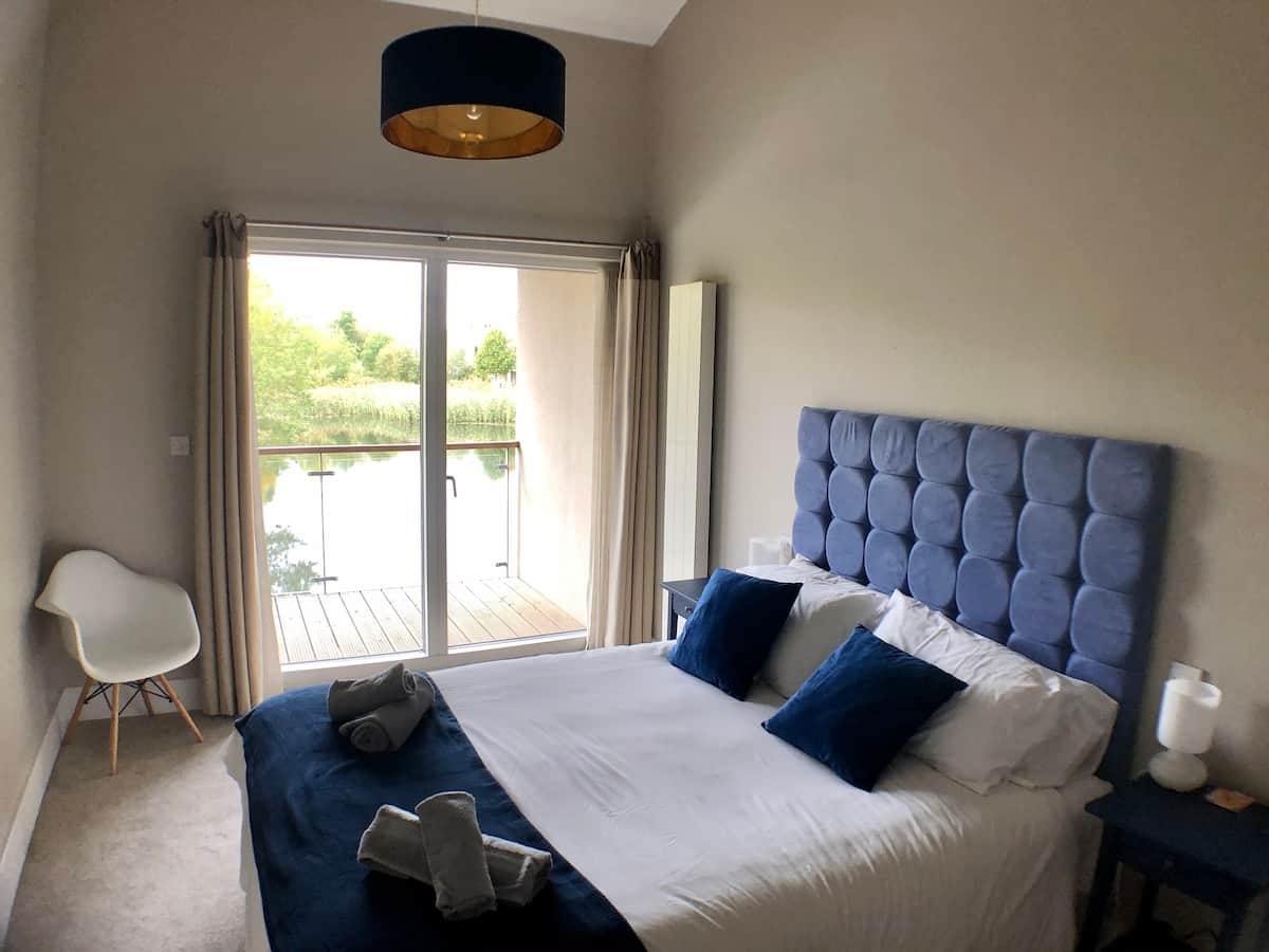 Bedroom 1, king bed and en-suite bathroom with shower. Patio doors lead to balcony with lake view