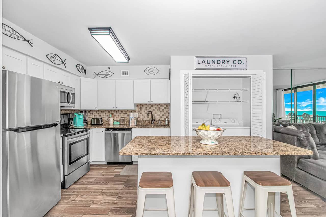 Fully equipped kitchen with island seating & in-unit laundry.
