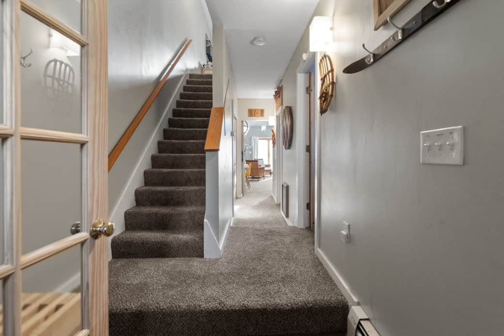 2nd Mudroom with bench, waterhog rug, coat hooks, looking down hallway (1st bedroom on right), stairs to second floor (2nd, 3rd, 4th BRs and 2nd full bath).  Hooks over heater helps dry out gloves, jackets etc.