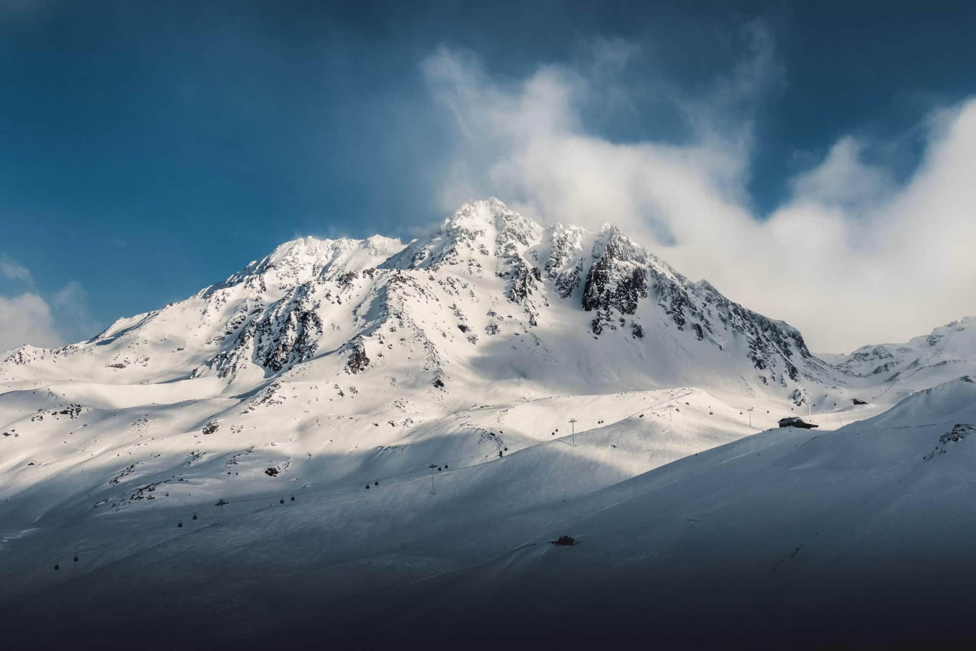 Sommets enneigés et remontées mécaniques de Val Thorens sous les nuages — NGF Hosting